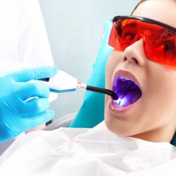 A picture of a woman getting a fillings at the dentist.