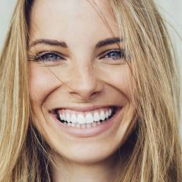 Portrait of young woman with beautiful smile after undergoing a cosmetic dentistry procedure.