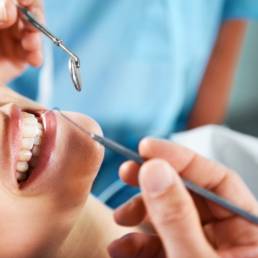 Young woman smiling widely while undergoing a general dentistry hygiene procedure